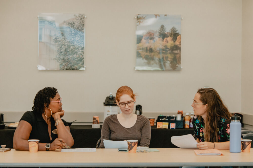 Group of three staff talking together